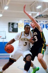 PUTTING IN WORK: Samohi's Mikhail Brown (left) makes a move toward the basket as Mira Costa's Jake Fader applies defense on Wednesday at Samohi. (Morgan Genser editor@www.smdp.com)