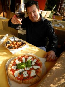 Oscar Morel, owner/chef of Il Piccolo Verde in Brentwood, salutes with a nice house Chianti and two signature dishes, Neapolitan pizza margarita and a world-class Cioppino. (John Blanchette editor@www.smdp.com)