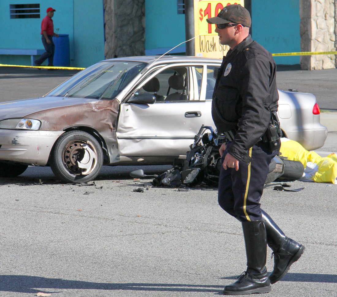 A Santa Monica police officer inspects the scene of a fatal traffic accident at the corner of 25th Street and Pico Boulevard on Monday. (Daniel Archuleta daniela@www.smdp.com)