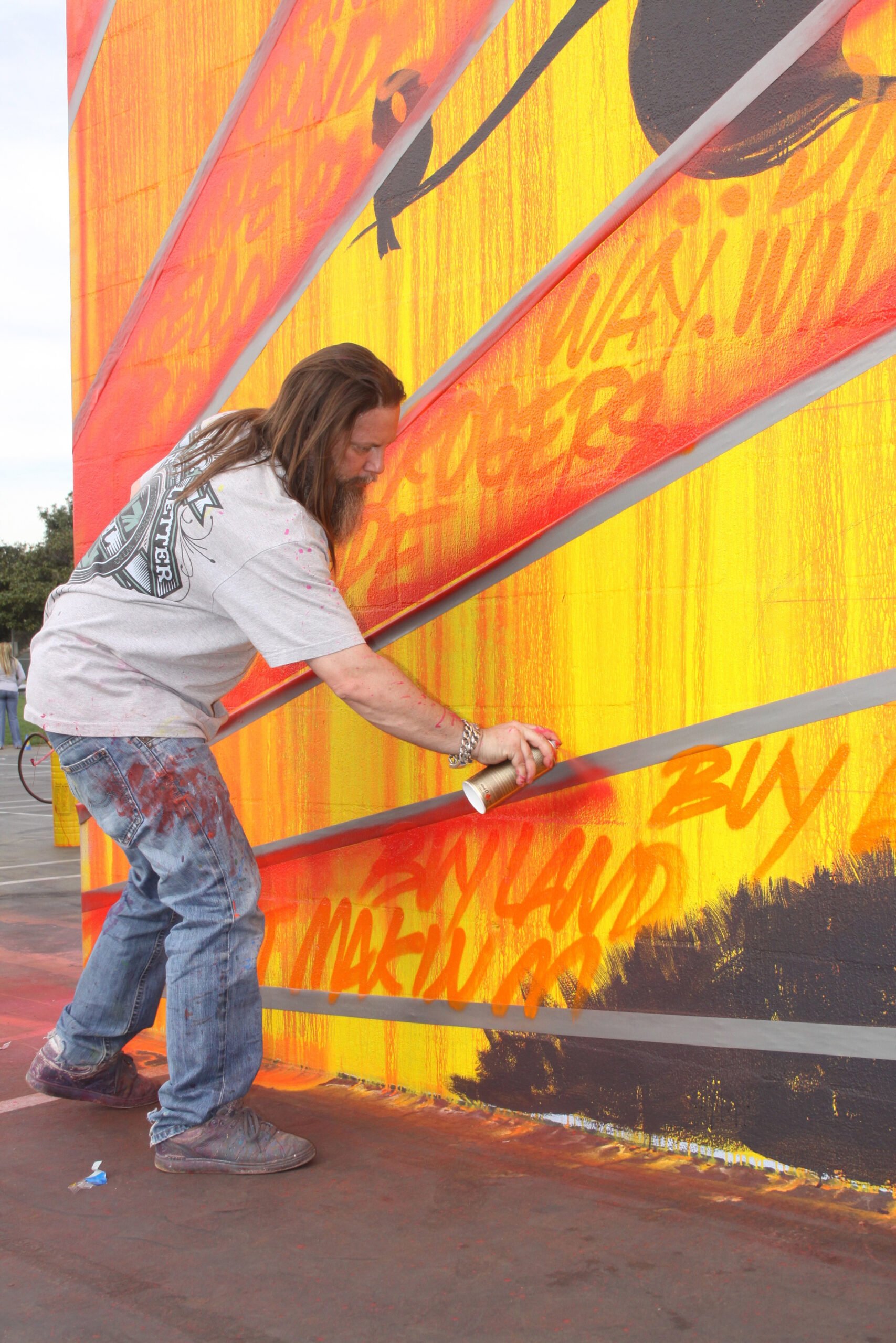 Graffiti artist Kelly 'Risk' Graval works on a mural at Will Rogers Elementary School last week. (Ray Solano editor@www.smdp.com)