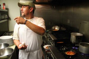 AT WORK: Cook George Ramos busy preparing food at Spitfire Grill on Thursday. The popular eatery is among a group of businesses which are unsure of their futures in light of a recent City Council decision to explore closing the controversial Santa Monica Airport. (Daniel Archuleta daniela@www.smdp.com)