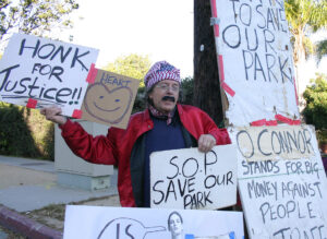 Village Trailer Park resident Peter Naughton protests the closure of the park on Wednesday.  (Photo by Daniel Archuleta)