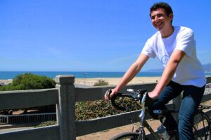 ROLLING: Benji Miller rides his bike through Palisades Park while listening to his invention, the Allo smartphone speaker. (Daniel Archuleta daniela@www.smdp.com)