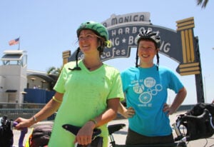 Rachel Horn and Owen Gorman pose under the Santa Monica Pier sign in the days leading up to their cross-country journey. (Photo by Daniel Archuleta)