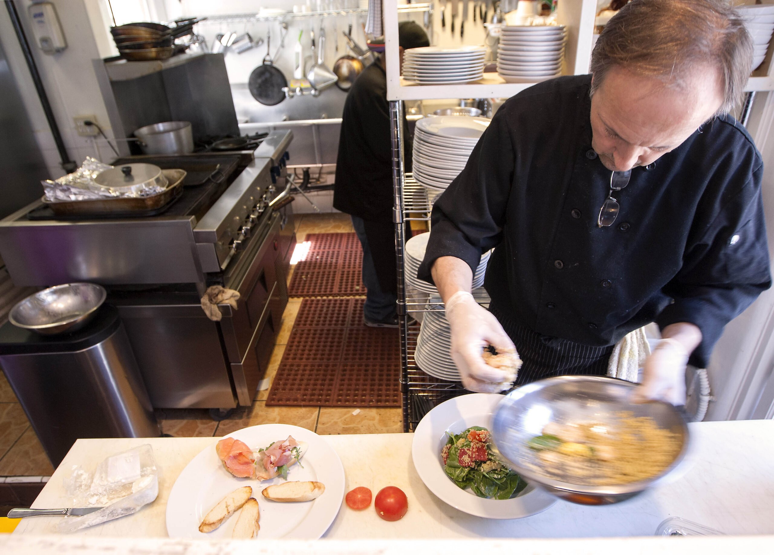 Chef and owner Art Selimovic prepares a salad for a customer at The Courtyard Kitchen on Montana Avenue. (Michael Yanow editor@www.smdp.com)