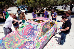 Students from Santa Monica Alternative School House (SMASH) paint the 'SuperSMASH' car in 2011. (File photo)