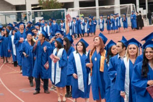 Students wave to their family members and friends as they walk to the Santa Monica College 2011 graduation ceremony at the Corsair Field. (File photo)