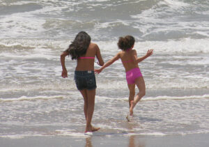 A pair of young girls play in the surf at Santa Monica State Beach earlier this year. (Photo by Daniel Archuleta)