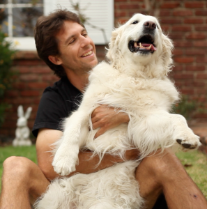 Josh Garrett plays with a friend's dog. (Photo courtesy Mercy for Animals)