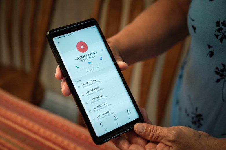 Patti Balogh holds up the phone of her late son, Shane Balogh, to show how many times he had been trying to get through the state's Employment Development Department at her home in Garden Grove on July 19, 2023. Photo by Julie A Hotz for CalMatters