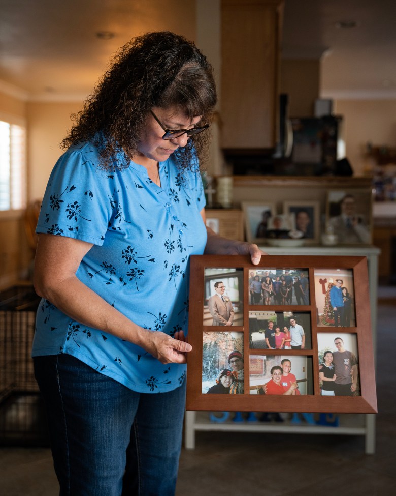 Patti Balogh holds up a frame of photos of her late son, Shane Balogh, at her home. Photo by Julie A Hotz for CalMatters