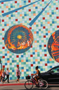 BUSTLING: Downtown visitors pass by a massive mural on Second Street on Thursday. (Daniel Archuleta daniela@www.smdp.com)