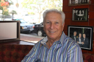 The man, the myth, the Deli Lama Izzy Freeman seated in one of his 40-year-old restaurant's plush booths. The walls of Izzy's Deli are covered by photos of celebrities who call Freeman a friend, helping his eatery earn the title 'Deli to the Stars.' (Photos by Michael Ryan)