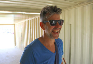 French artist Mathieu Briand walks through storage containers Tuesday on Santa Monica Beach that will become his '6:43 p.m.' exhibit for Saturday's GLOW. The project will ultimately be buried in sand with a ring of fire rising above it. (Daniel Archuleta daniela@www.smdp.com)