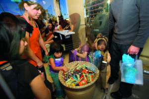 Trick-or-treaters grab candy at a nail salon on Montana Avenue. (File photo)