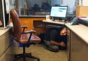 SAFETY FIRST: City Hall receptionist Jeff Snyder covers under his desk during The Great California ShakeOut drill on Thursday morning. (Paul Alvarez Jr. editor@www.smdp.com)