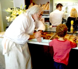 Chef Alain Giraud helps a young customer at the pastry counter of his Palisades restaurant Maison Giraud. ( Photo courtesy John Blanchette)