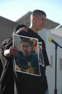 A friend of Eduardo 'Eddie' Lopez, 15, holds up a photo of the young man during a memorial service at Santa Monica High School in 2006. Lopez was shot and killed while walking with friends along Pico Boulevard. (File photo)