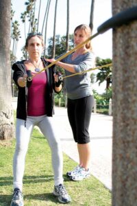 A fitness trainer works with a client in Palisades Park. (File photo)