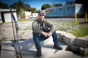 Cris McLeod sits in front of a vacant lot at Mountain View Mobile Home Park on Friday afternoon. He is one of a handful of residents who have filed a $121 million claim against City Hall for allegedly failing to maintain the park and treat tenants fairly. (Brandon Wise brandonw@www.smdp.com)