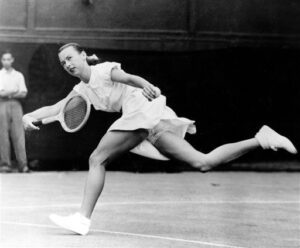 In a June 22, 1949 file photo, Gertrude "Gussie" Moran races across Centre Court to make a return shot in third round women's singles match in Wimbledon, England. Moran, who shocked the modest mid-century tennis world when she took the court at Wimbledon with short skirt and ruffled underwear, died Wednesday in Los Angeles. She was 89. (Photo courtesy Associated Press.)