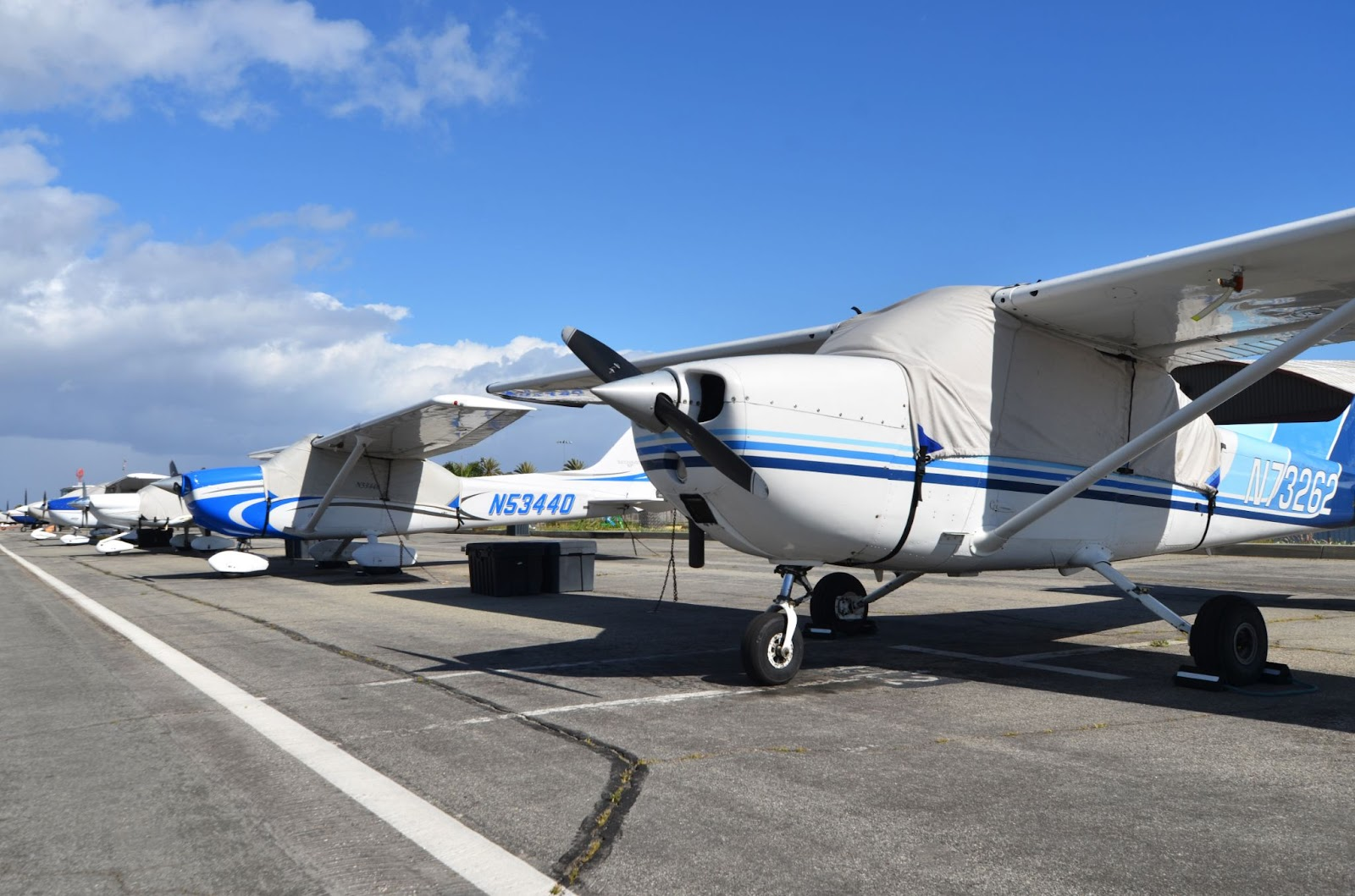 A closeup, looking north-east , of a row of parked, private planes at Santa Monica Airport