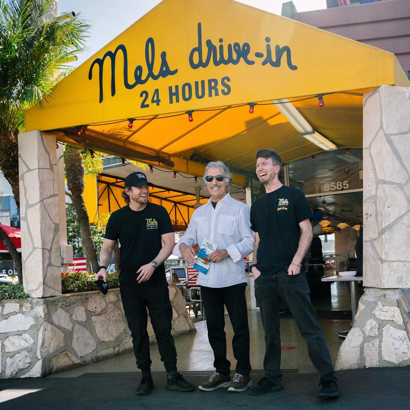 Mel's founder son and grandsons pose in front of one of Mel's restaurants. 