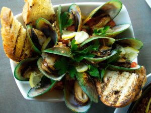 FRESH AND CLEAN: New Zealand green mussels with spicy butter, chorizo and blue cheese. (Photo courtesy Maggie Louie)