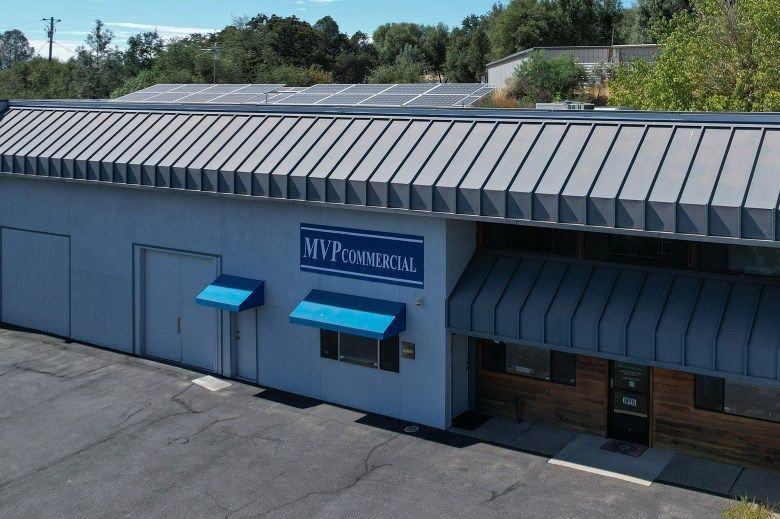 An aerial view of the MVP Commercial building with a grey and blue exterior that includes a sign with the building's name.